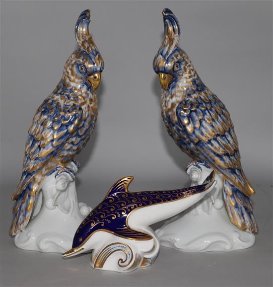 A Royal Crown Derby dolphin paperweight (gold stopper) and a pair of Portuguese porcelain cockatoos